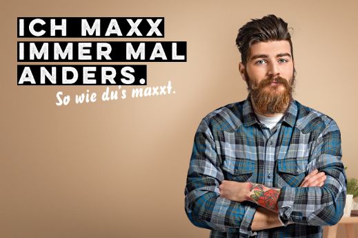 Werbesujet für «Der scharfe Maxx». Junger Mann mit Bart und blaukariertem Hemd.