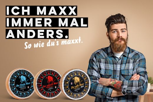 Werbesujet für «Der scharfe Maxx». Junger Mann mit Bart und blaukariertem Hemd.