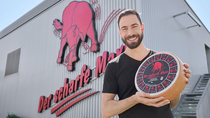 Mister Maxx 2025 mit einem Käselaib Der scharfe Maxx in der Hand.