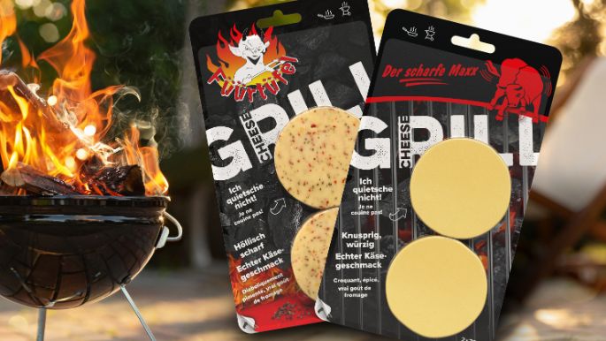 Abgepackter Grillkäse der Käserei Studer mit loderndem Feuer in einer Feuerschale im Hintergrund.