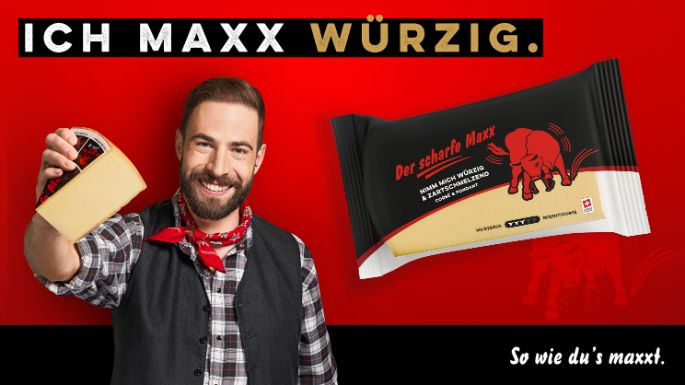 Markenbotschafter Der scharfe Maxx mit Käsestück in der Hand.