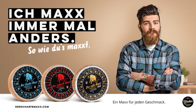 Werbesujet für «Der scharfe Maxx». Junger Mann mit Bart und blaukariertem Hemd.