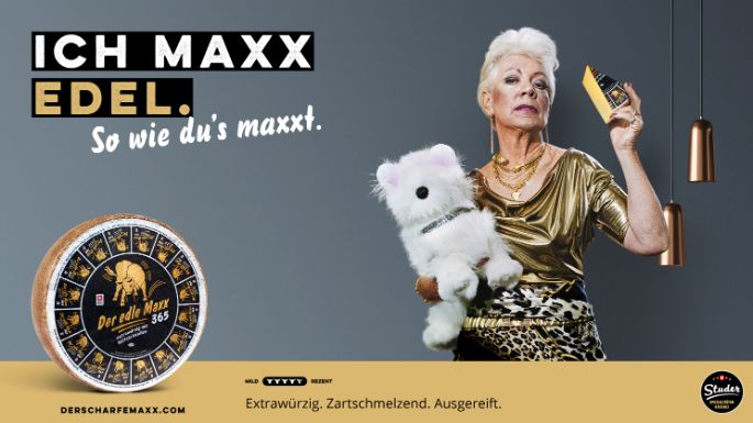 Werbesujet für den Käse «Der edle Maxx 365». Ältere Dame mit Hund und einem Käsestück in der Hand.